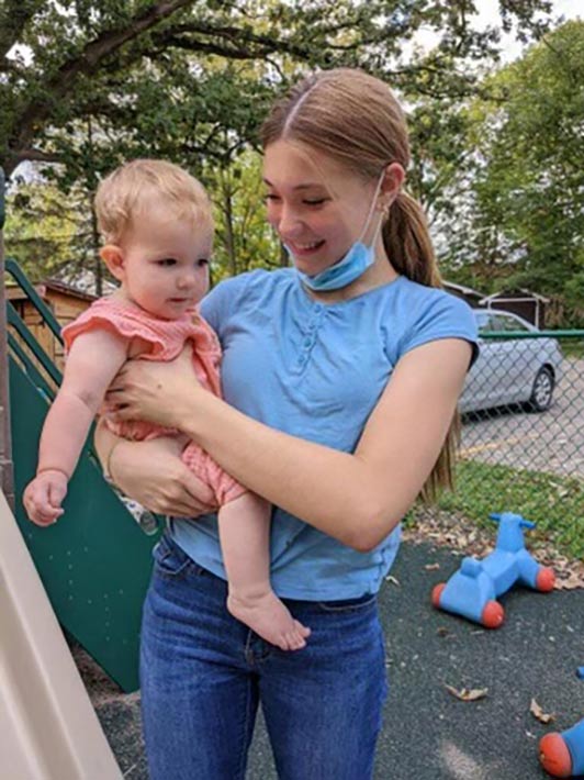 A student volunteer holding a baby